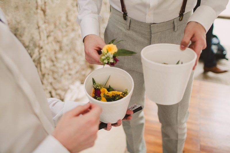 Groom making his boutonniere before his destination wedding